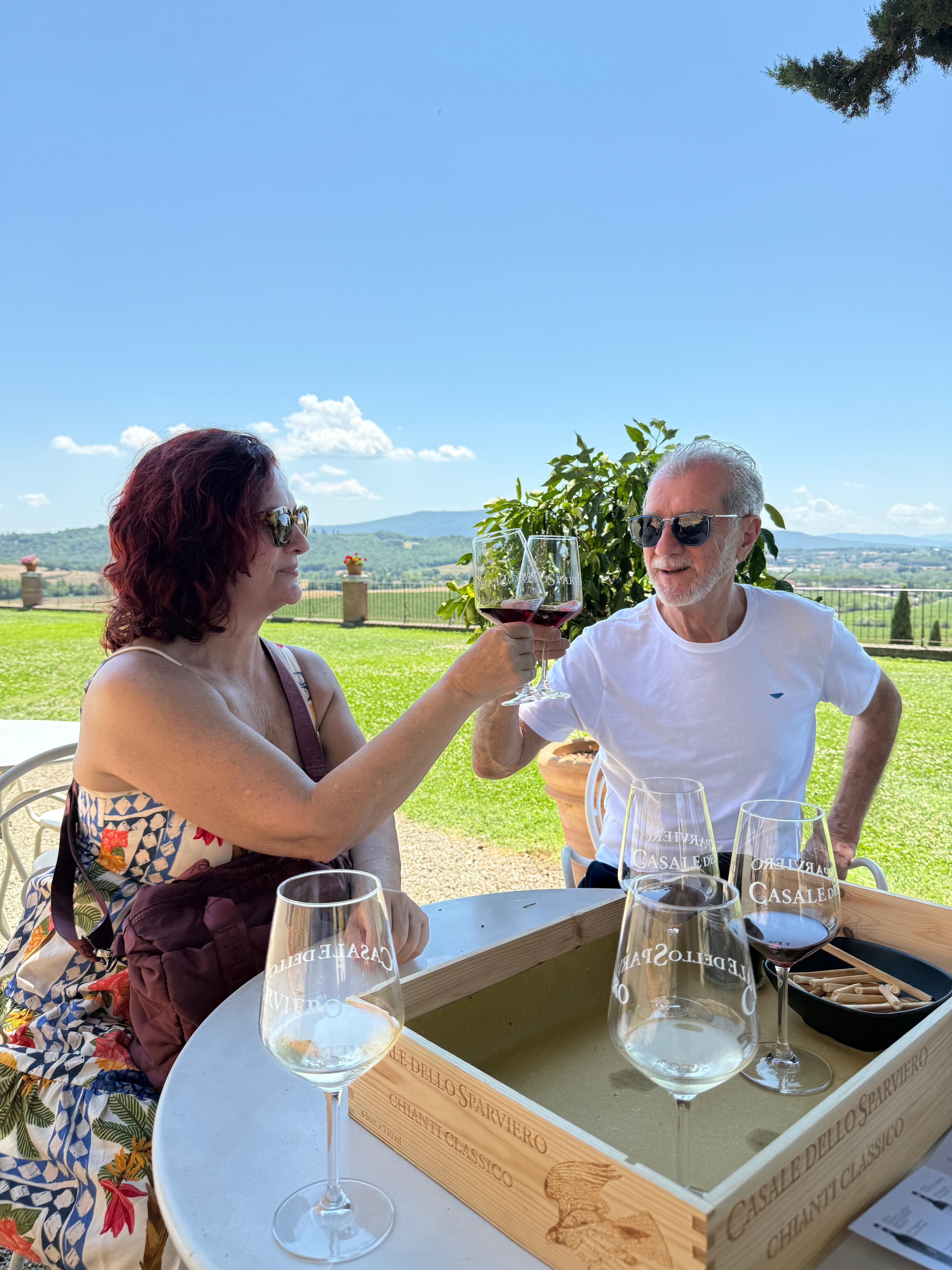 Casal cliente da Harpya brindando em vinícola na Toscana, Itália
